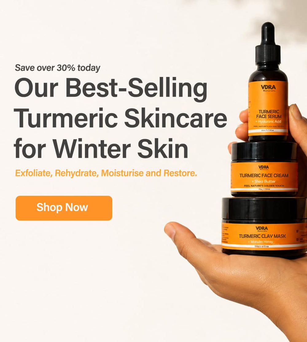 VDRA turmeric skincare products held by a hand with promotional text on a white background