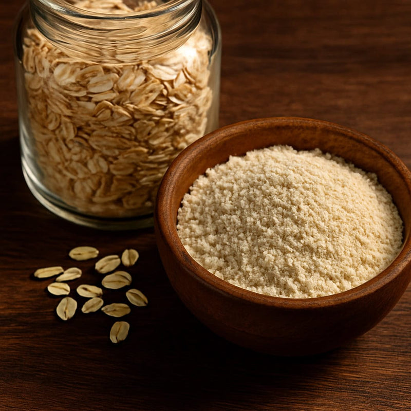 Glasss jar of rolled oats and a wooden bowl of oat flour on a wooden surface