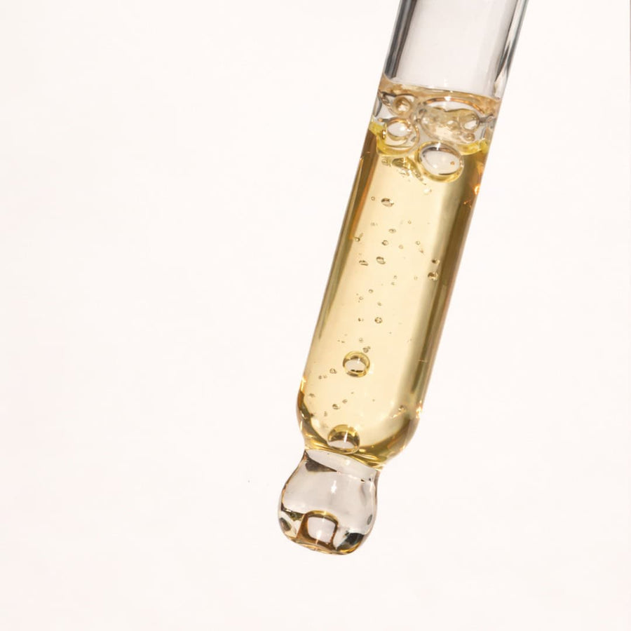 Lightweight turmeric face serum on a dropper, non-greasy golden texture