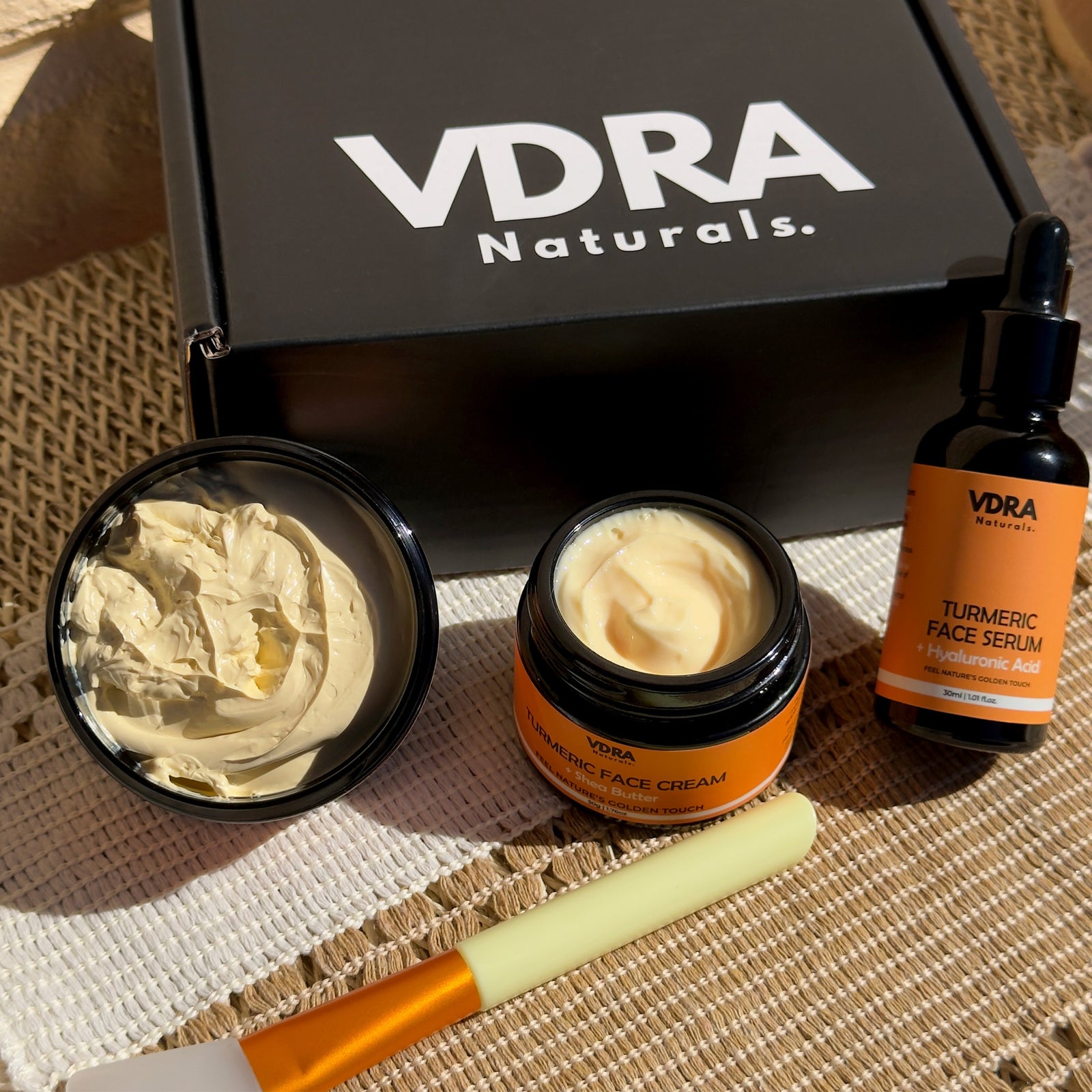 VDRA Naturals turmeric trio bundle, including a serum, cream, and clay mask with it's lid open showing off it's textures.